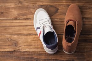 Casual and dressy mens shoes on wooden table