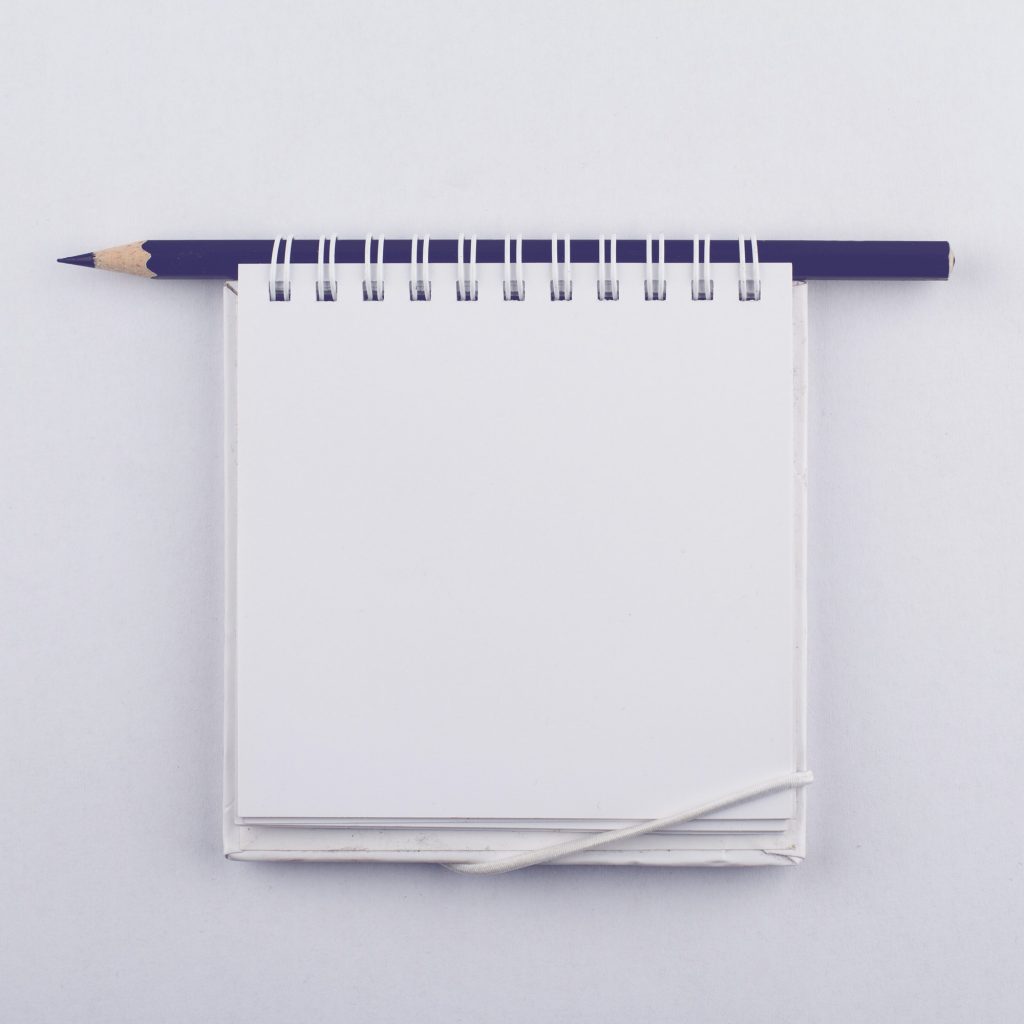 Empty paper notebook with spiral and a black pen