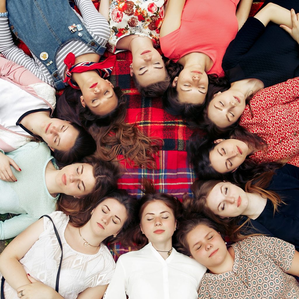 happy group of women faces in circle posing and smiling on picnic